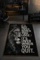 Siyah Aslan Figürlü Motivasyon Yazılı Oyuncu Halısı Tasarımı Siyah oyuncu halısında aslan yüzü, ingilizce motivasyon yazısı ve ince gold çerçeve yer alır