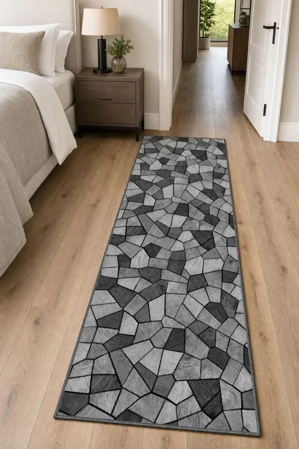 Antrede uzanan gri geometrik desenli dijital baskılı halı görünümündeki kesme rulo yolluk